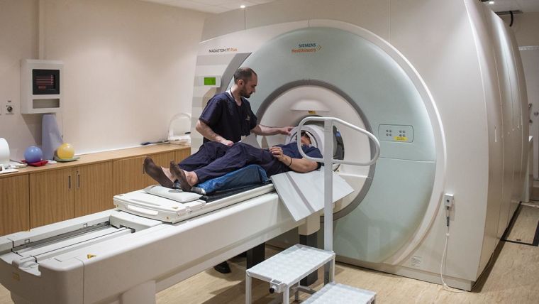 A radiographer and participant going into the MRI scanner