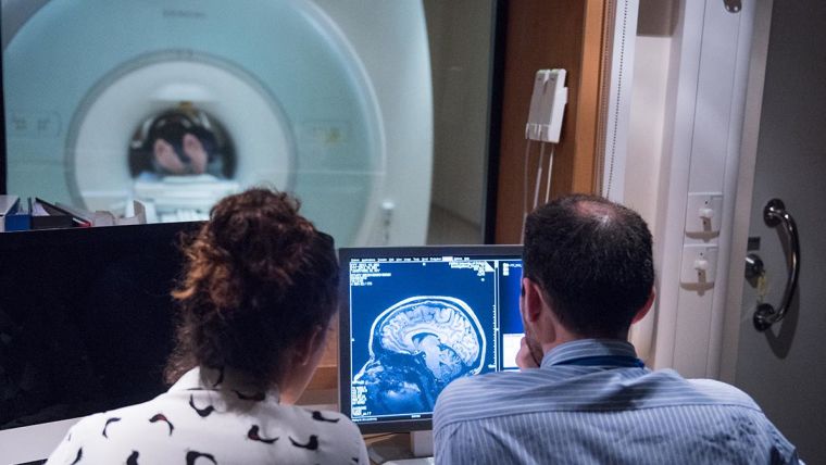 Two people working in MRI scan room